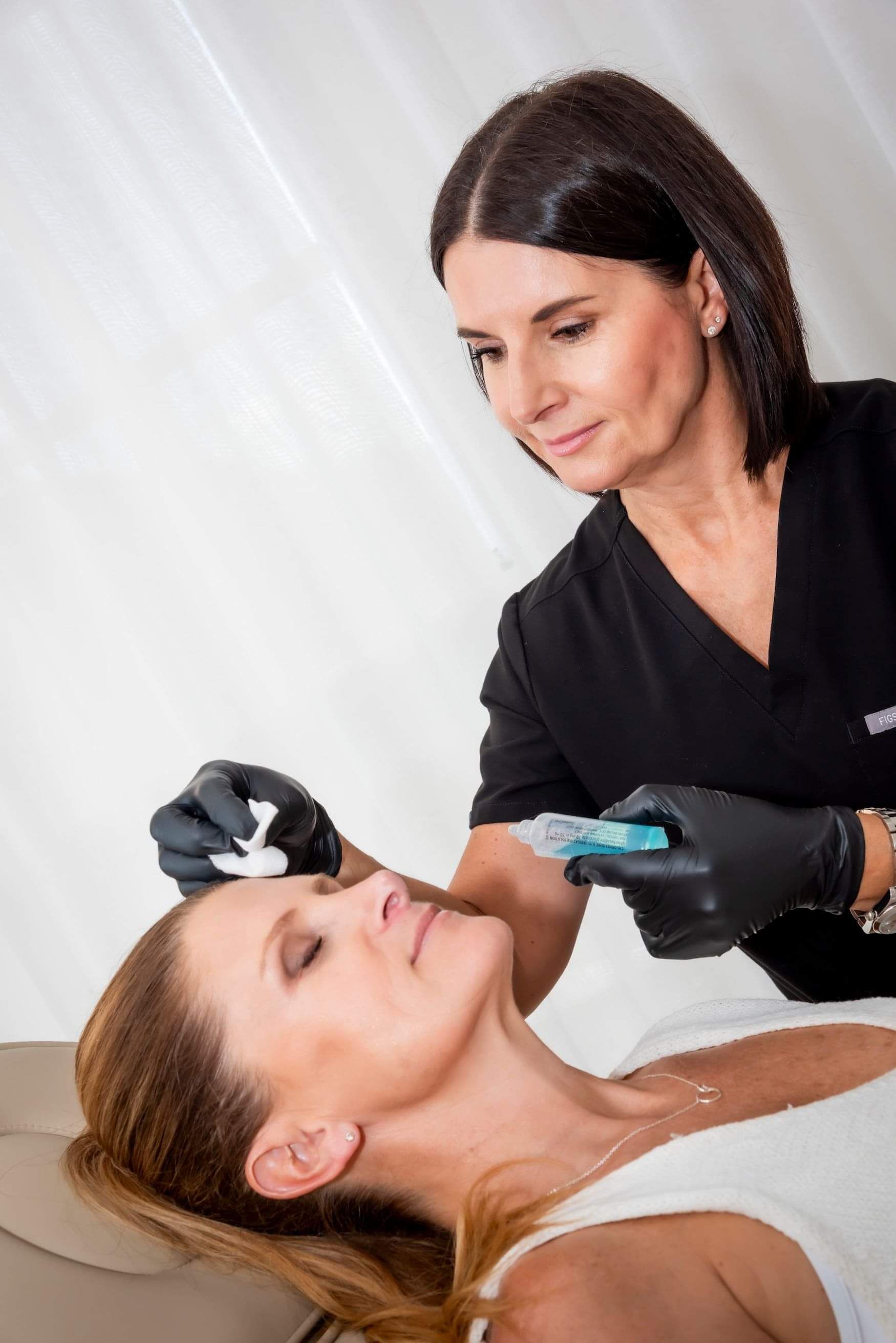 Bronwen professionally providing a skin booster treatment to a client at her Remuera Clinic.