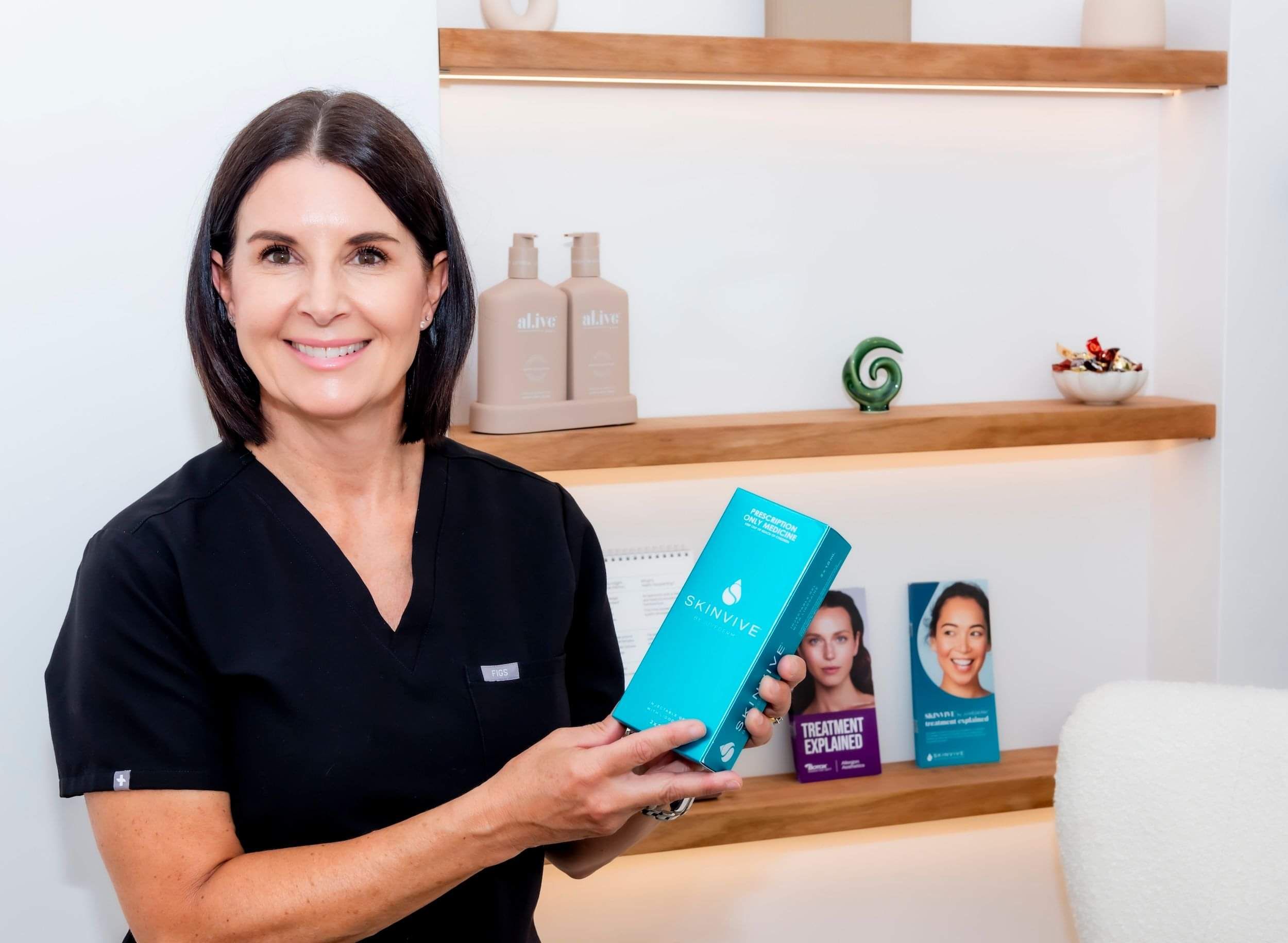 Bronwen holding a skin treatment that she recommends at her Skin Clinic in Remuera.