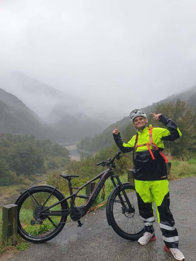 Misty Aotearoa mountains and Sam Troth with his bike — reflecting the courage, journey, and purpose that founded The Road to Healing Aotearoa.