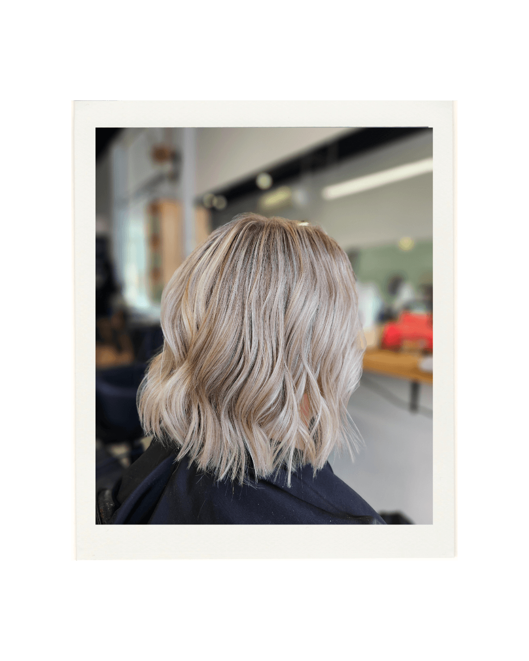 A polaroid style image of a wavy blonde bob created by Hair by Shiyee.