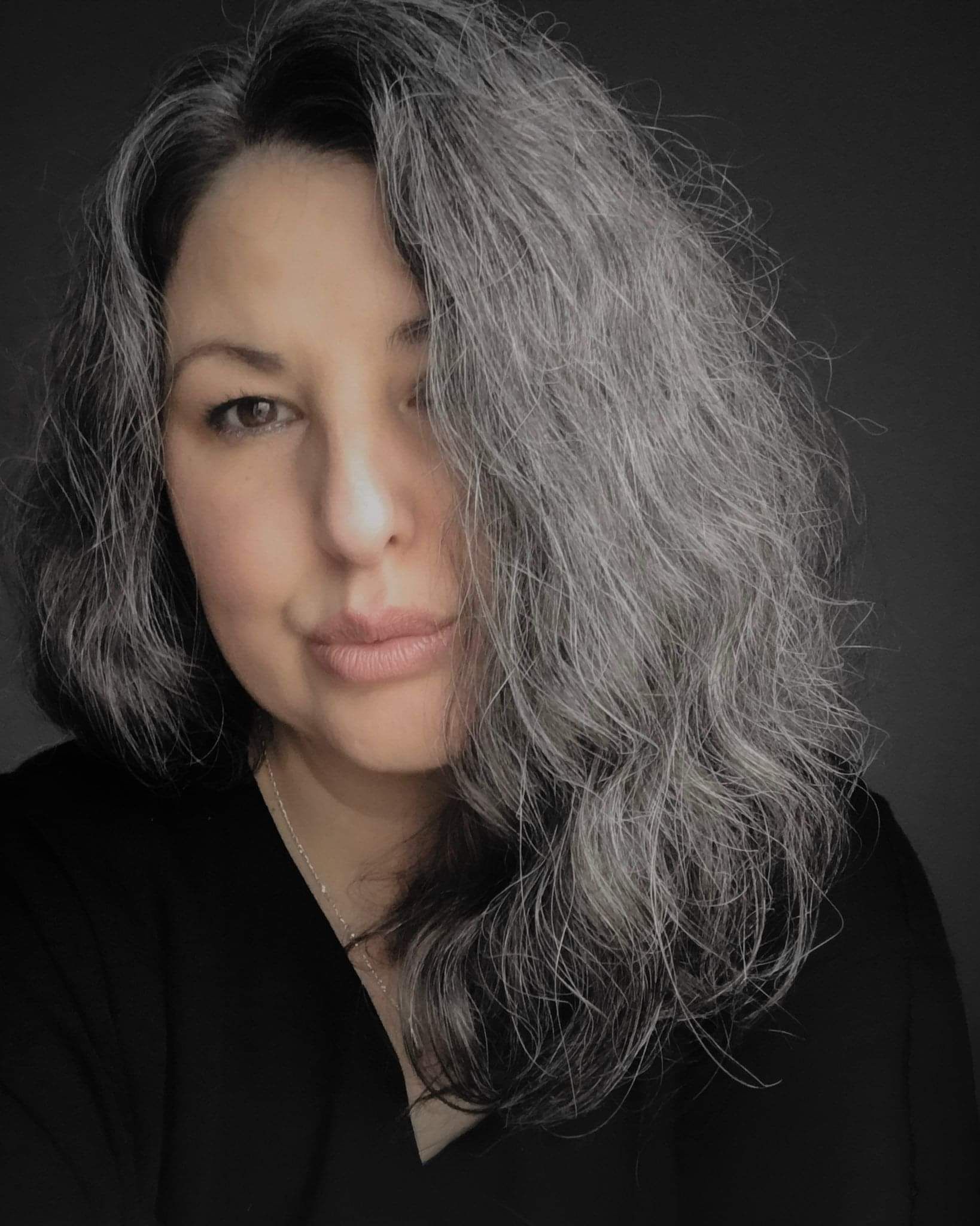 artist portrait with silver-grey hair and low atmospheric lighting