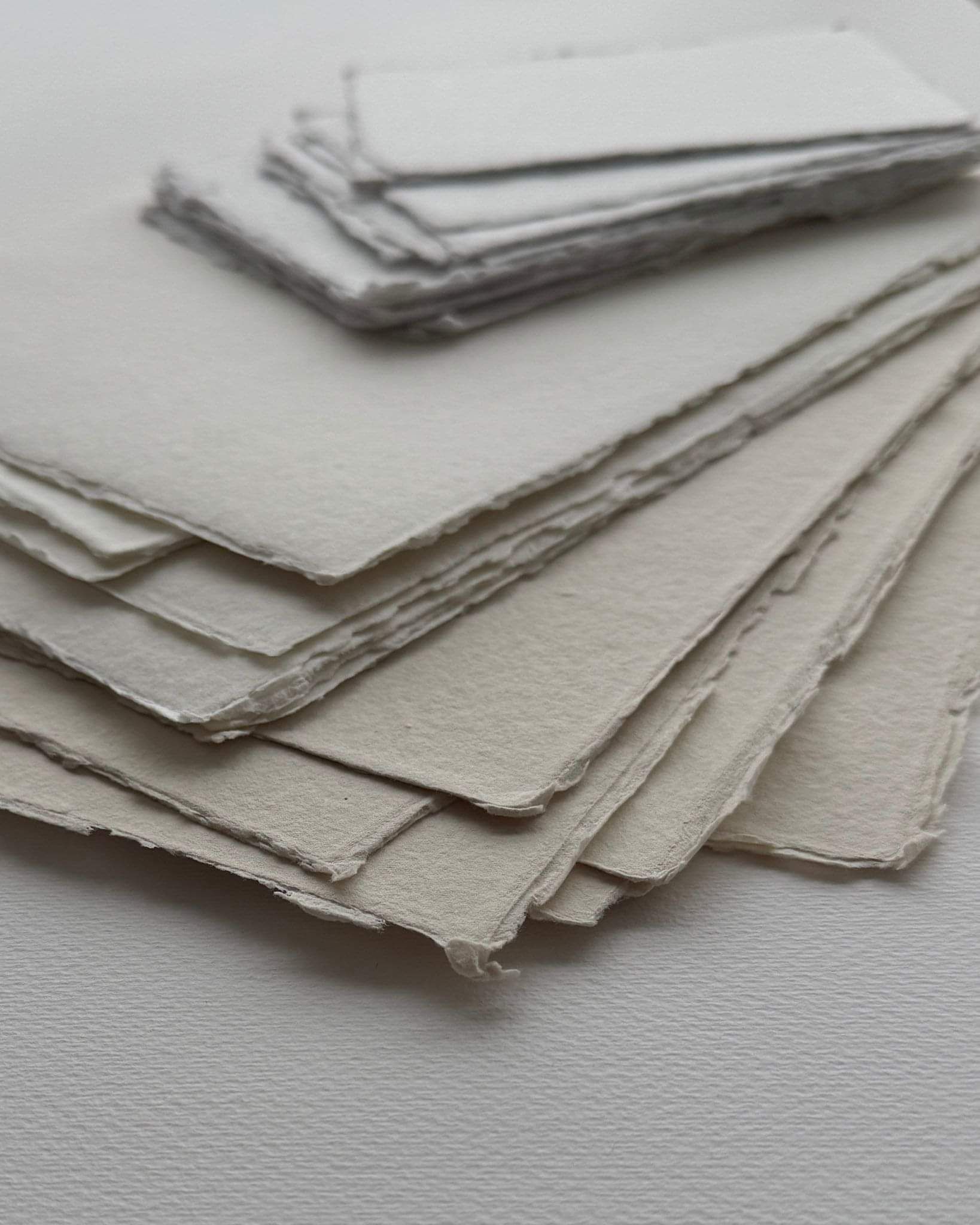 image of stacked handmade paper showing textured surfaces and irregular deckled edges