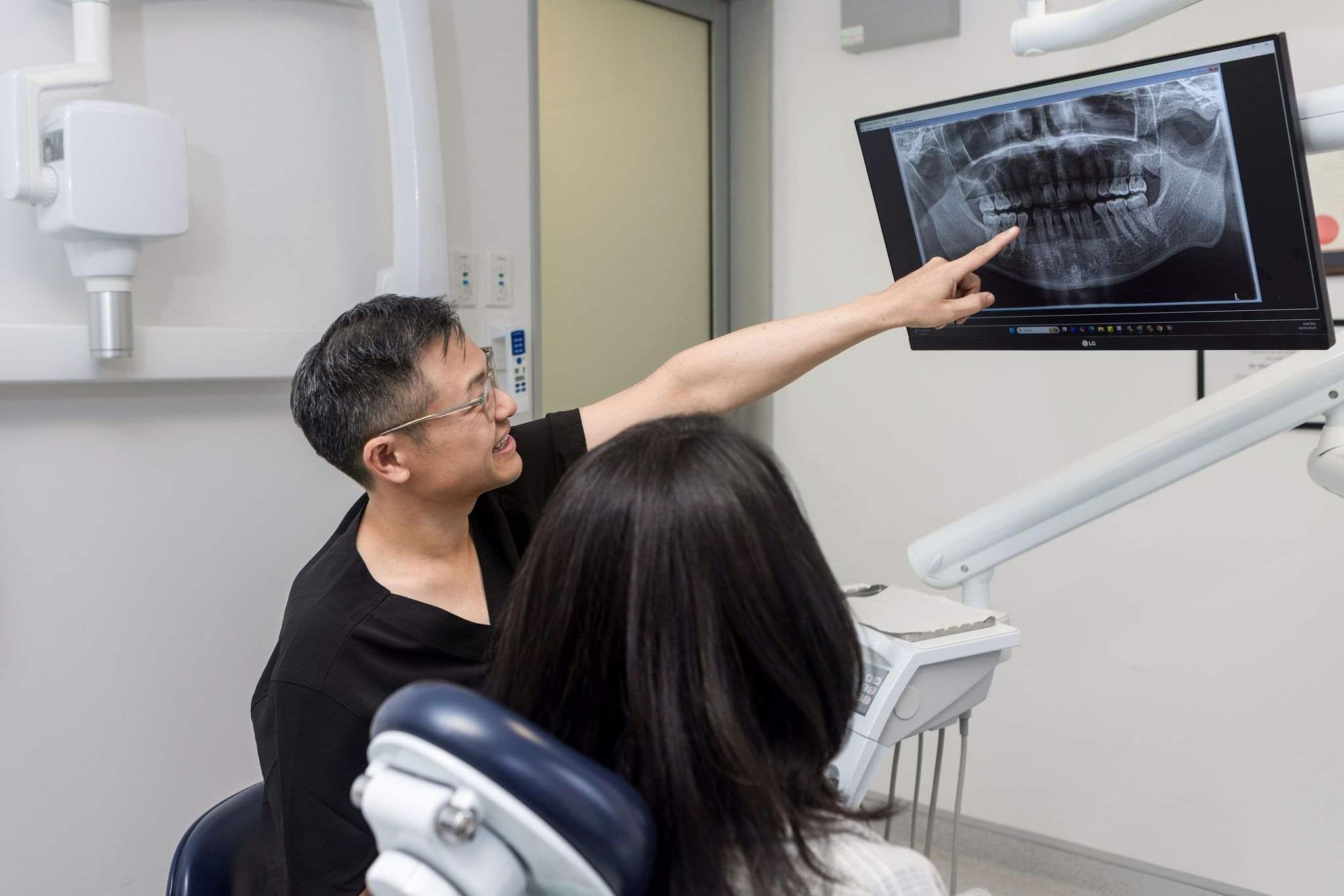 Dentist pointing to screen showing patient a dental scan