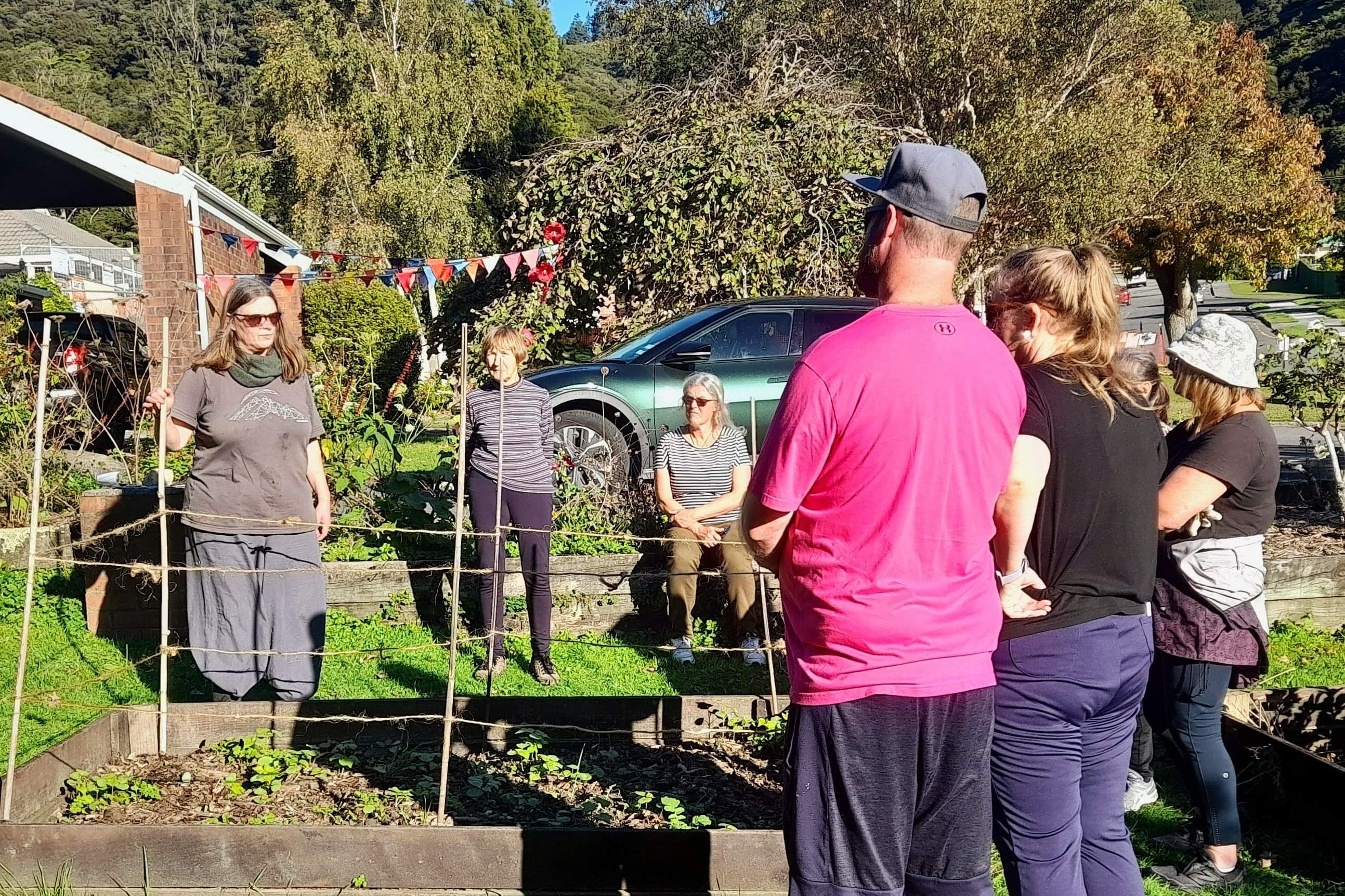Facilitator talkning to attendees outside at gardening workshop