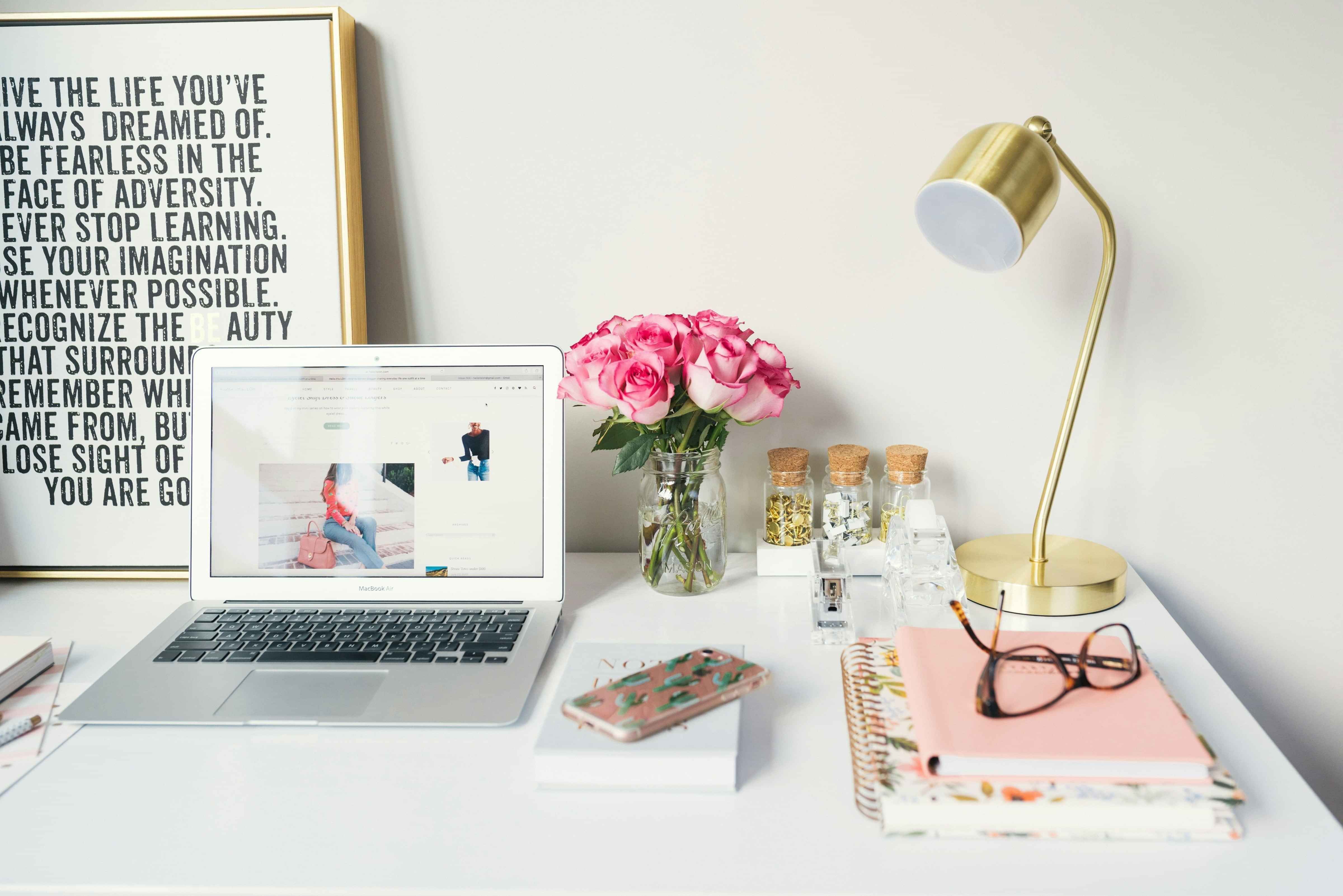 desk set up with laptop and pink accessories