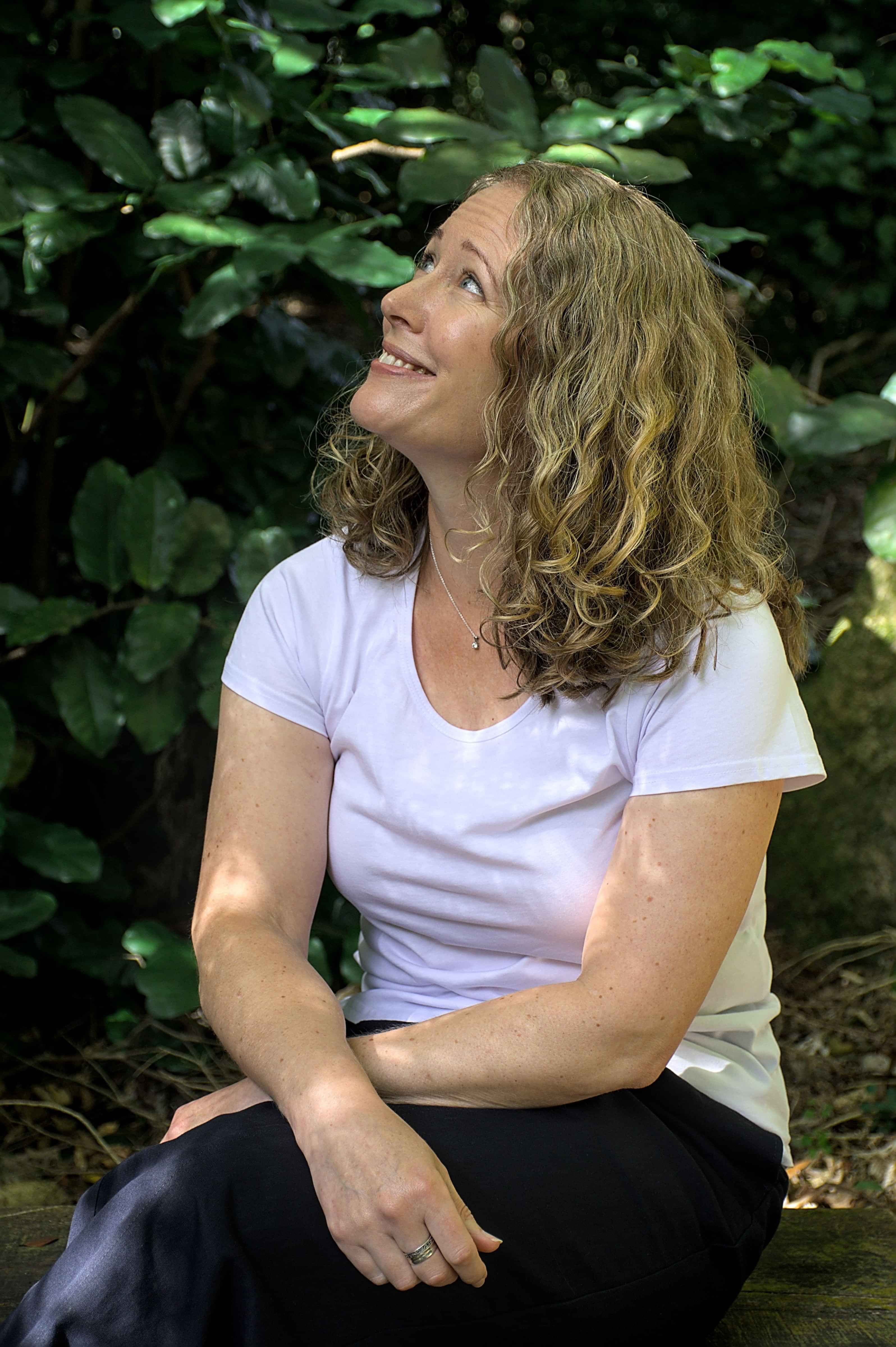 Woman looking up into the trees of a forest in Wellington, New Zealand