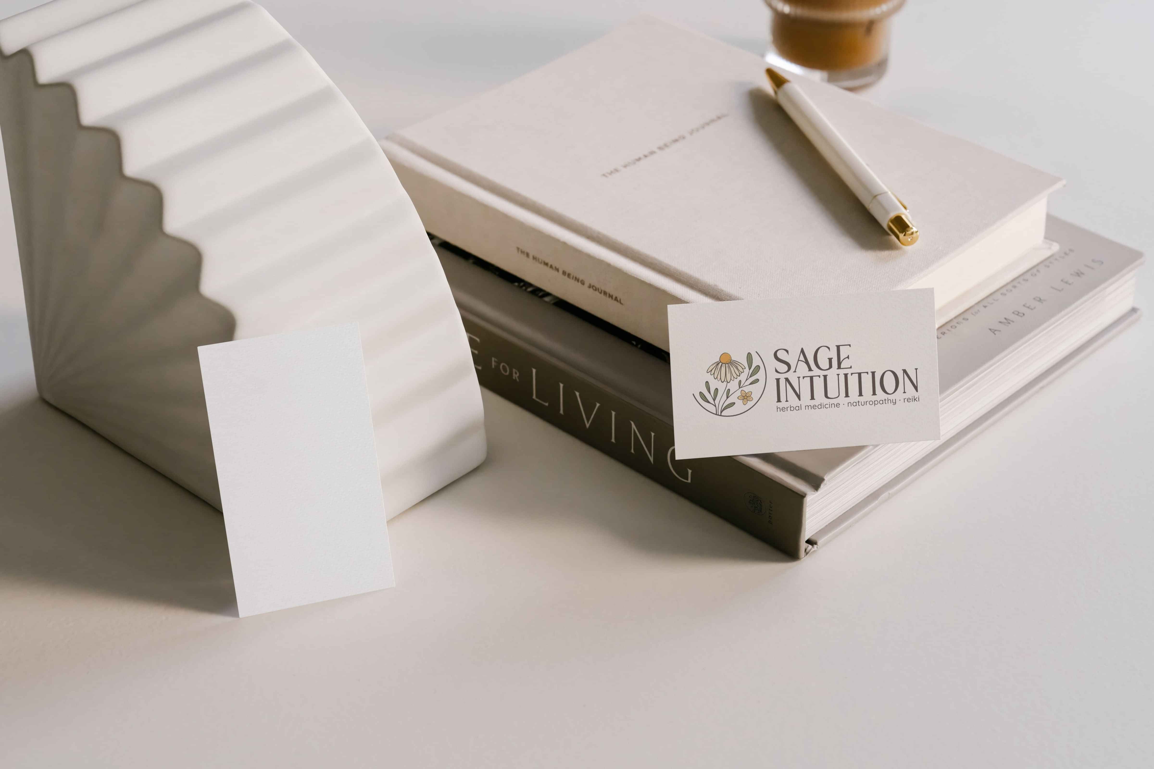 Image of Sage Intuition’s herb floral inspired business card on books. Designed by Creative Box. Waikato. New Zealand.