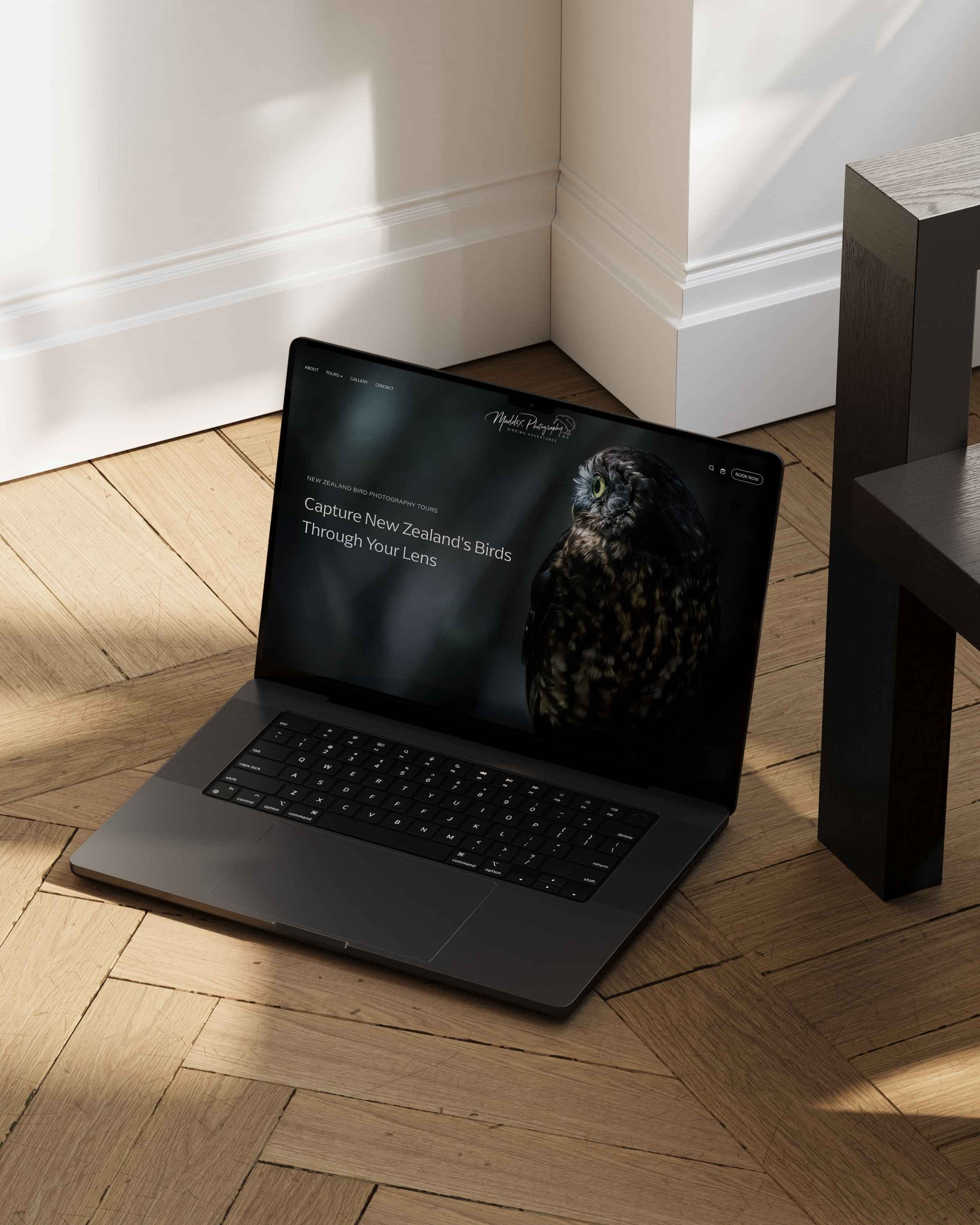 Image of black laptop mockup with Maddox Photography NZ’s website on a timber floor. Designed by Creative Box. Waikato. New Zealand.