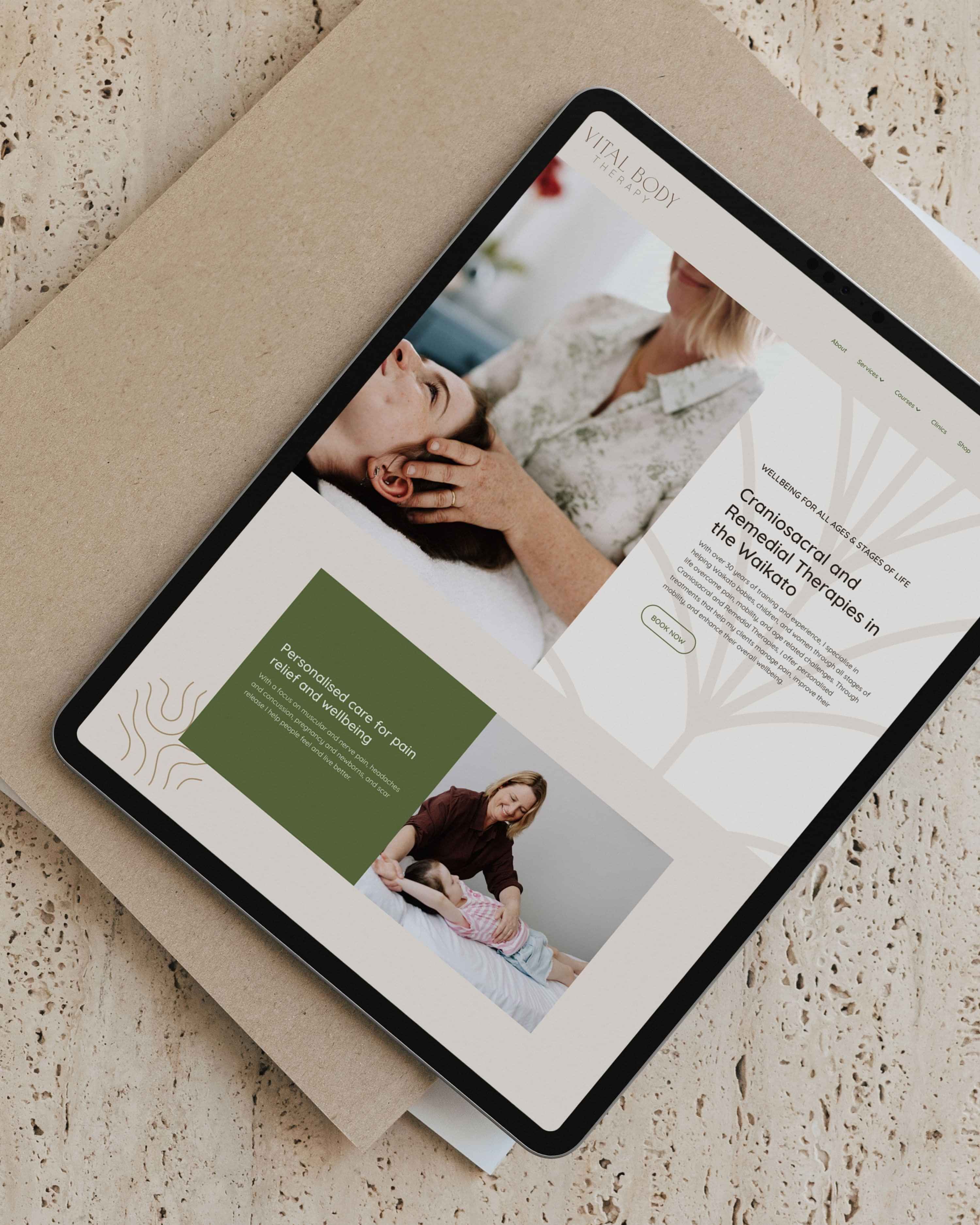 Image of ipad mockup with Vital Body Therapy’s website on a concrete table. Designed by Creative Box. Waikato. New Zealand.