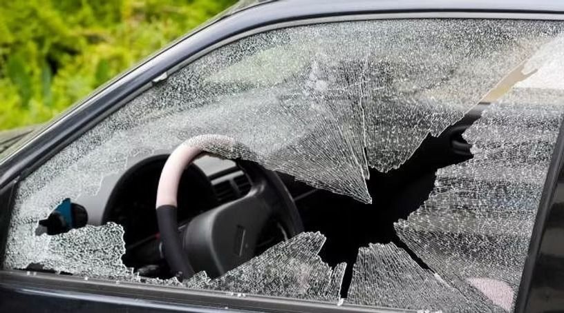 Smashed glass on the driver side window of a car