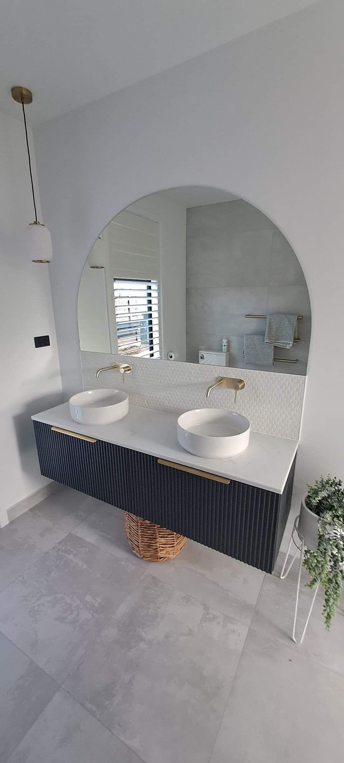 Curved mirror and his and hers bathroom taps and sinks
