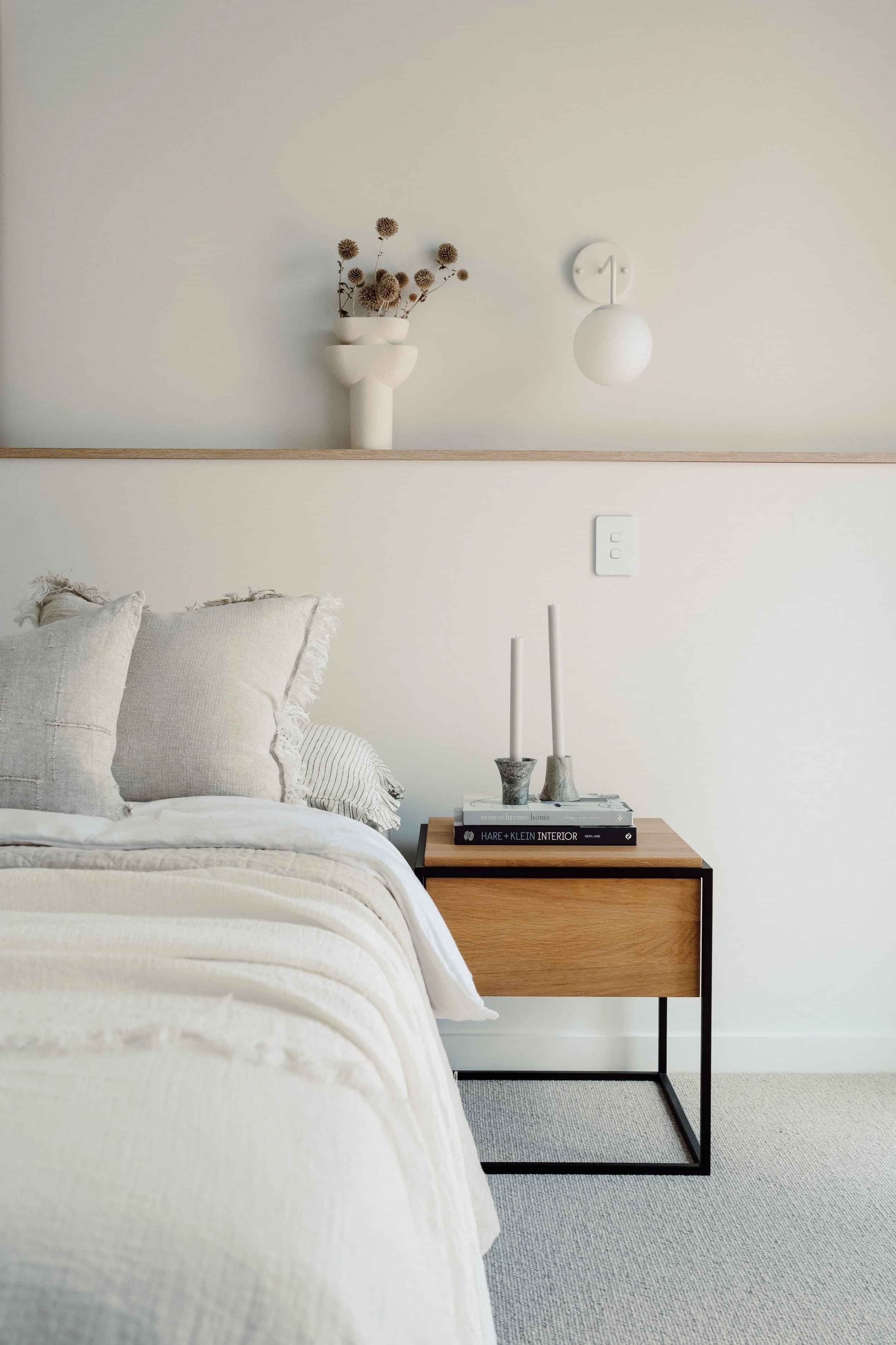 Bed with wooden side table and books