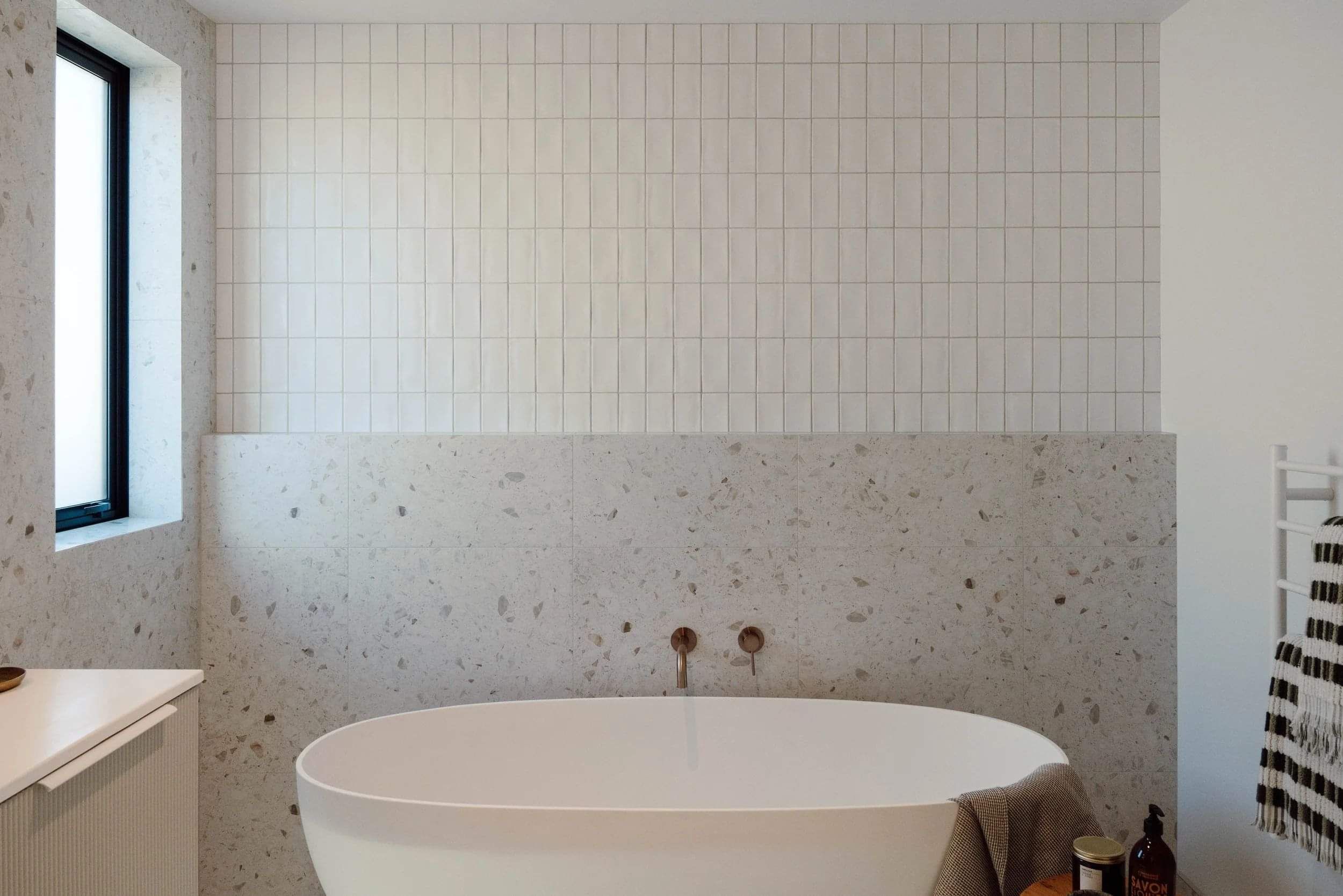 Modern floor to ceiling tiled bathroom with bath tub