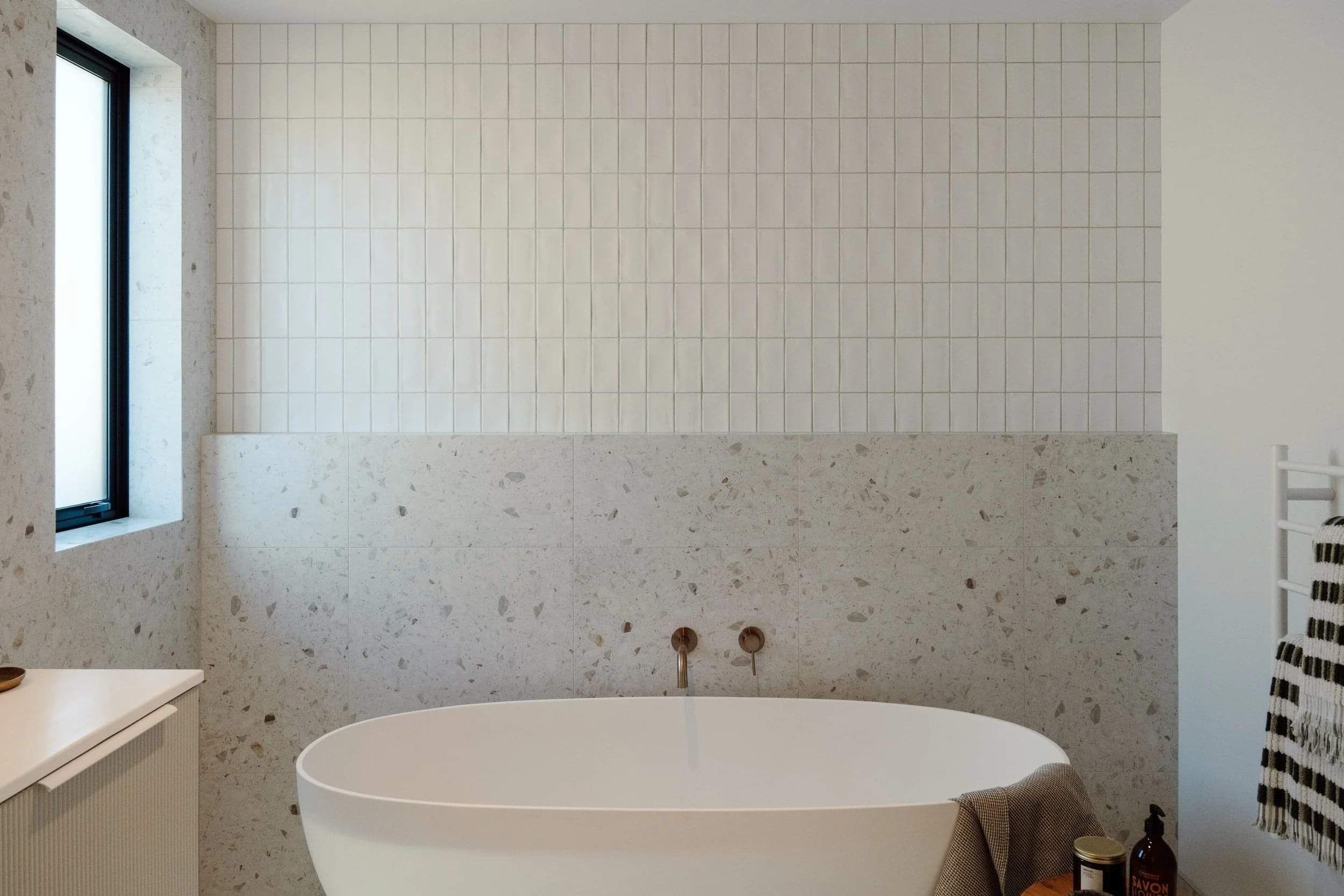 Modern bathroom with floor to ceiling tiles and bathtub