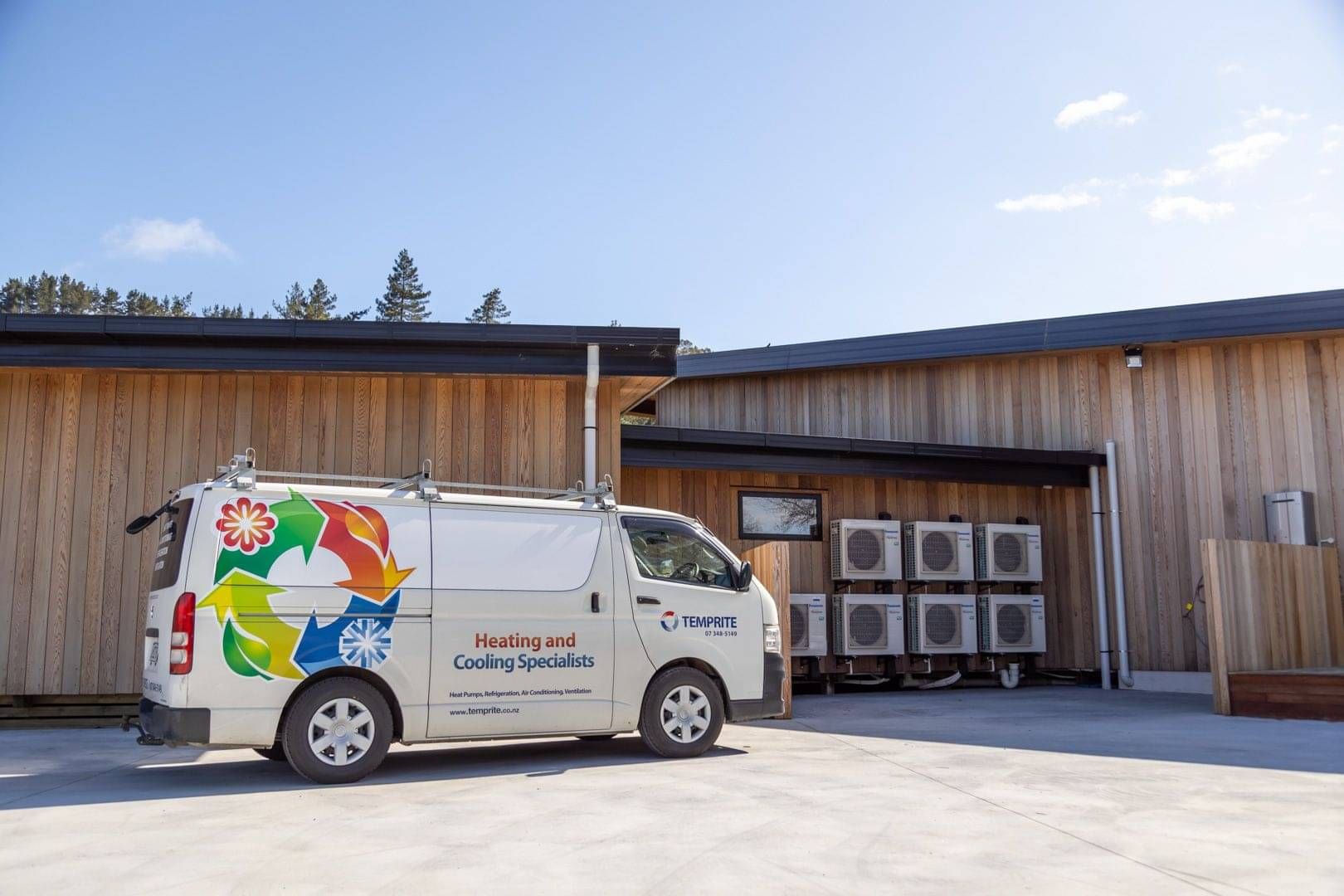 Temprite van parked beside a building with multiple outdoor heat pump units