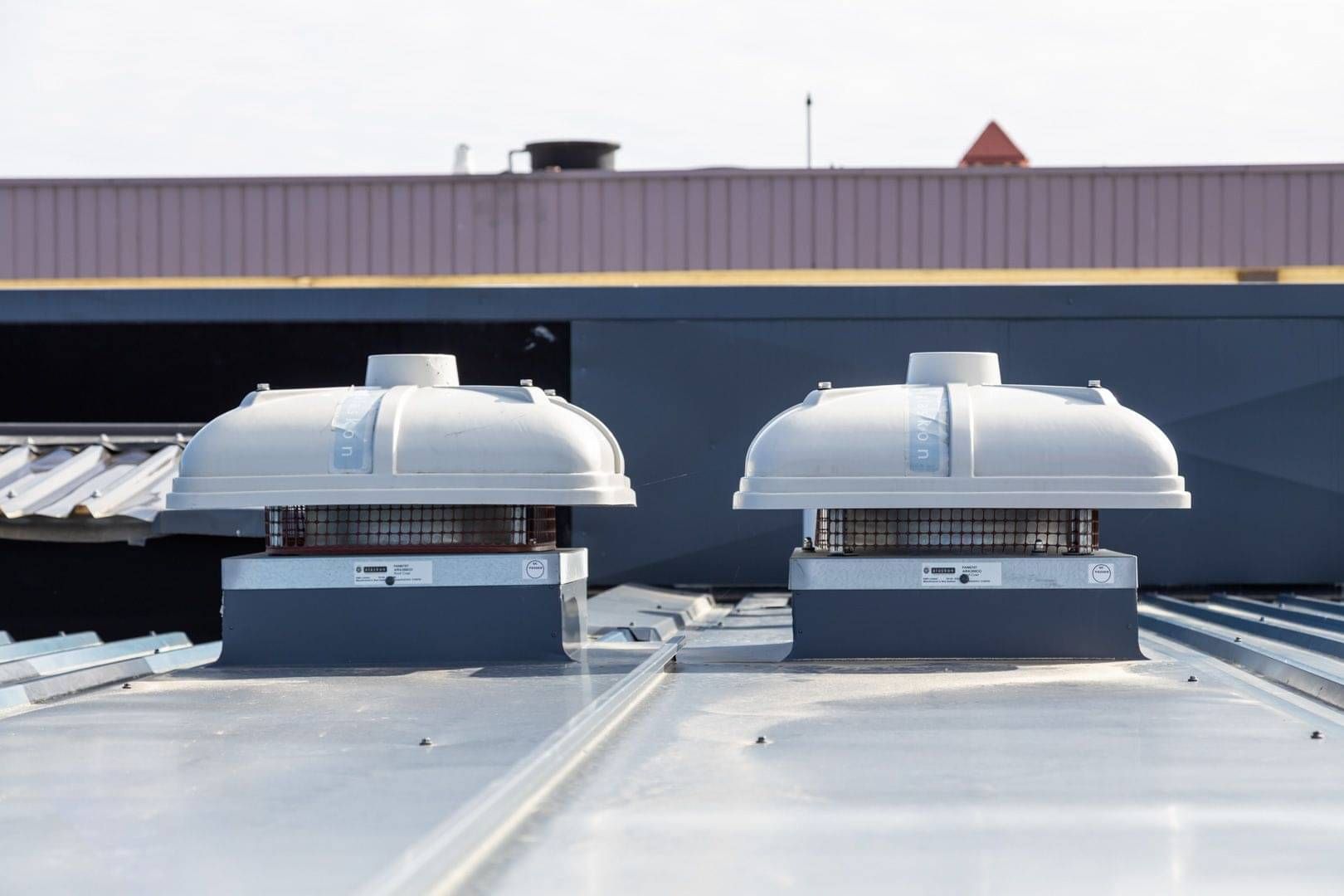 Rooftop extraction fans installed on a commercial building