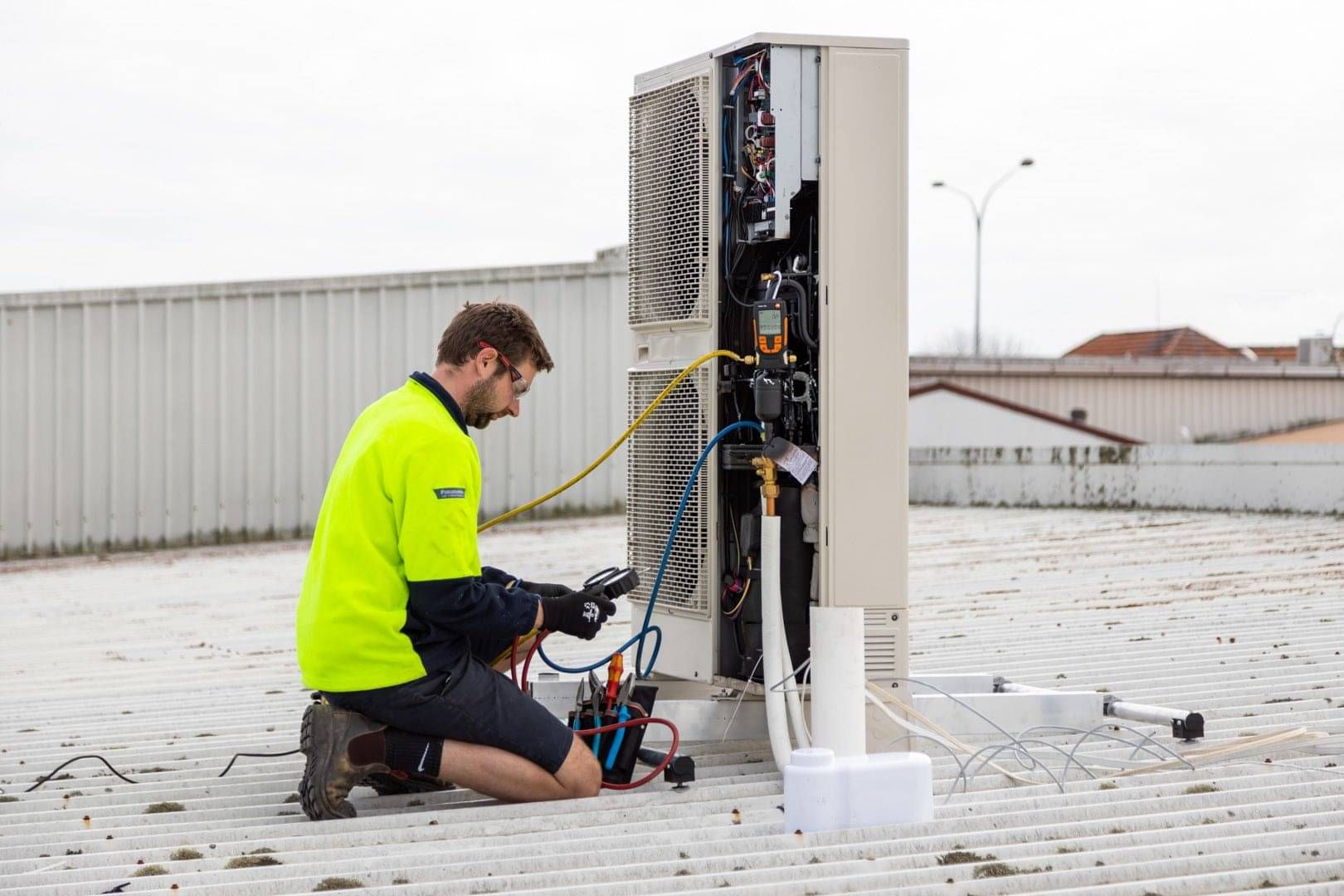 Technician servicing a commercial air conditioning unit