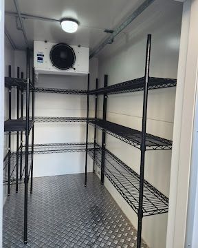 Inside a portable cool room with wire shelving and a chequer plate floor