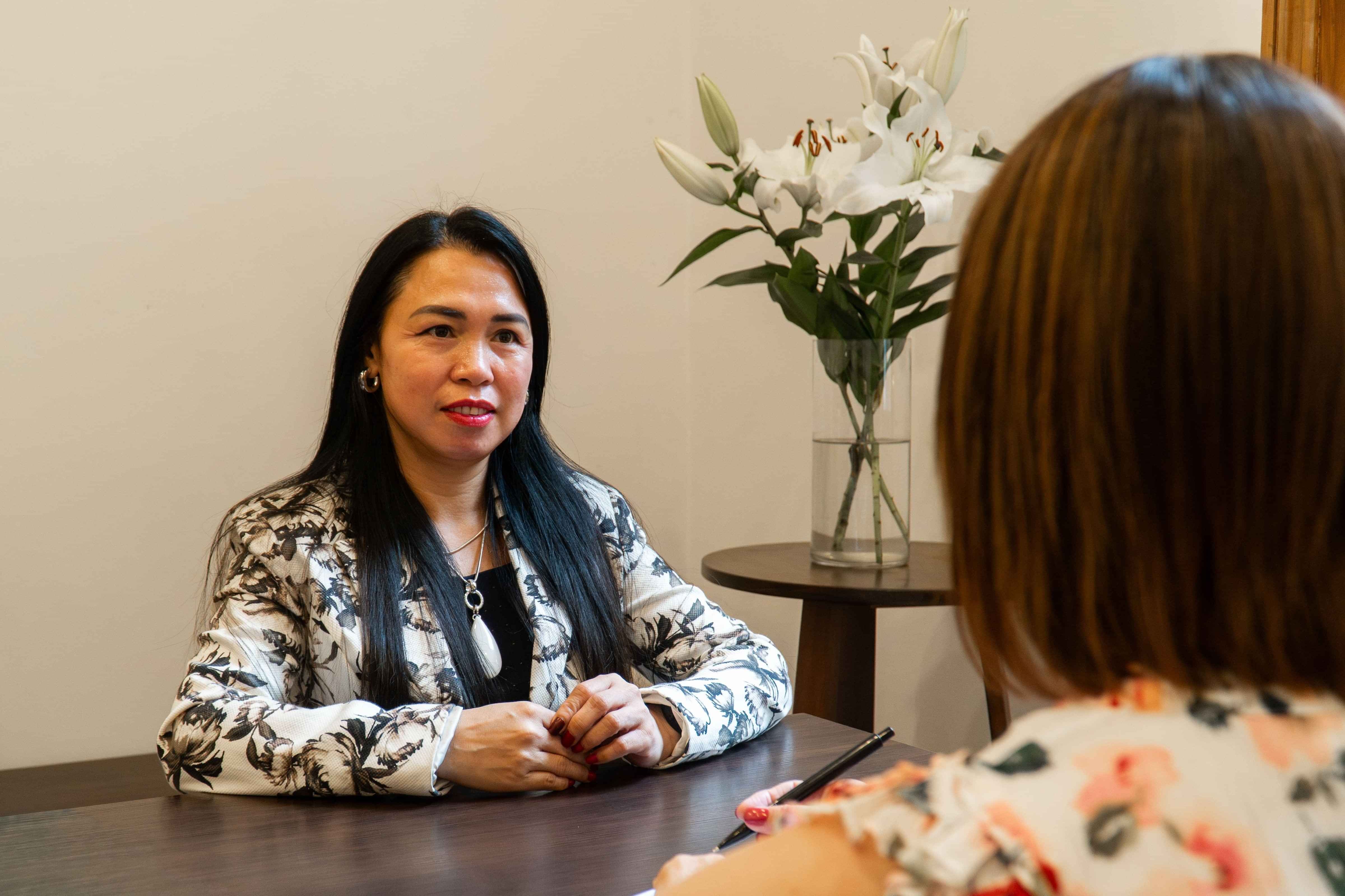 Dress for Success women client sitting at a table in a mentoring session with a staff member