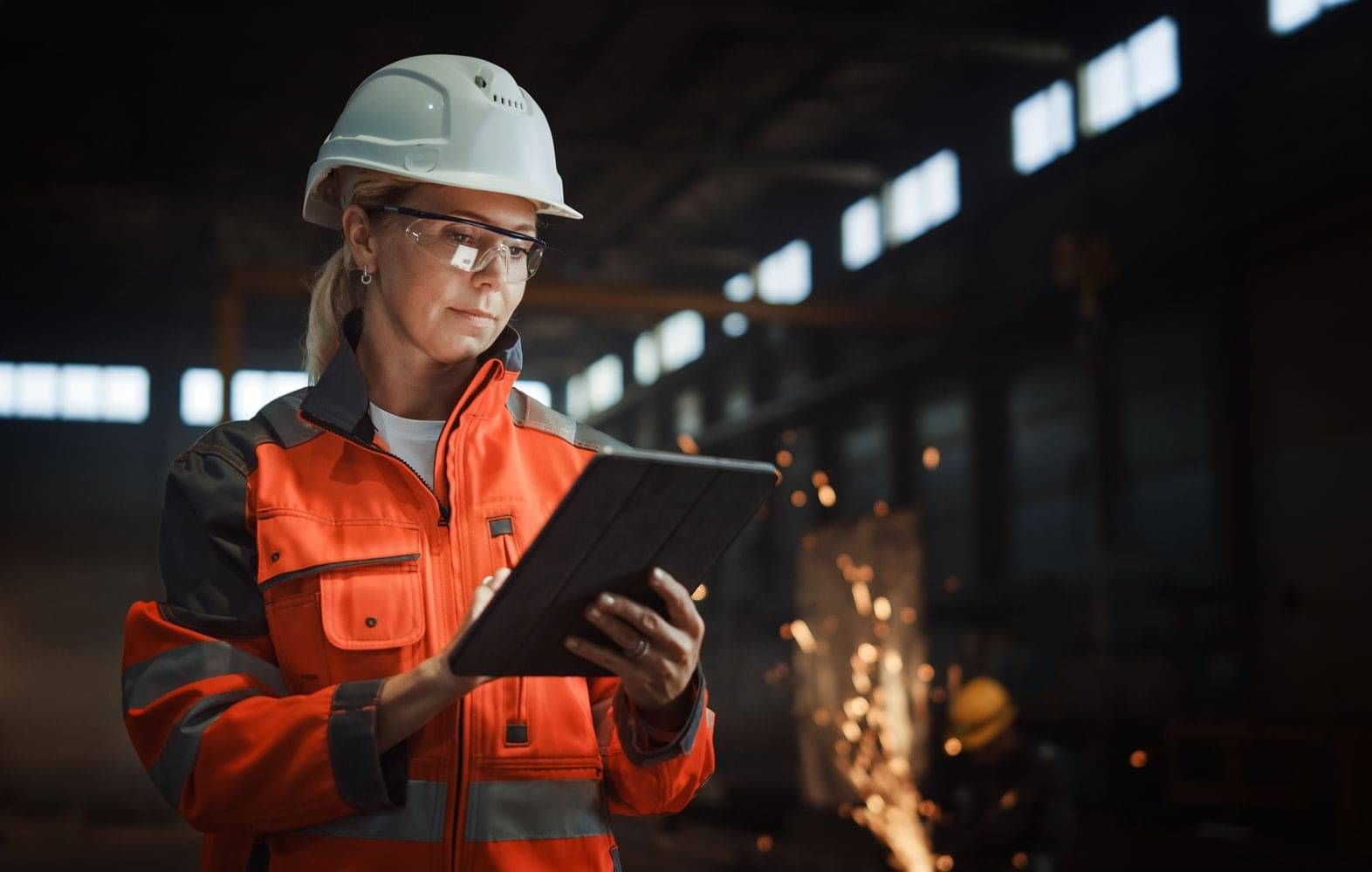 Worker using a tablet with CheckSafe competency management software in an industrial facility