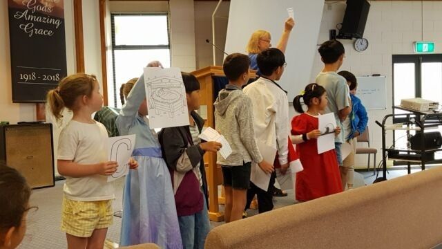 Image of children standing at front of church service