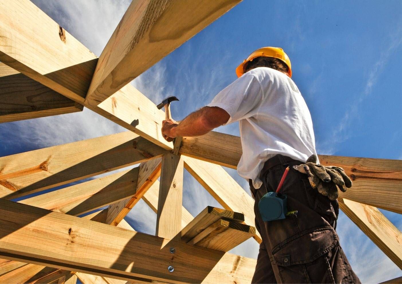 Builders working on the timber frame of a house under construction