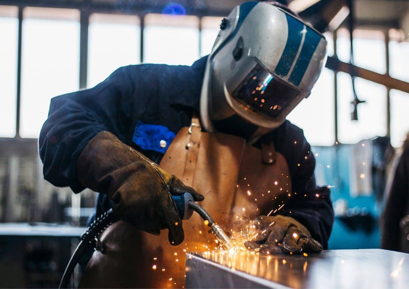 Welder working on a metal fabrication in a manufacturing workshop