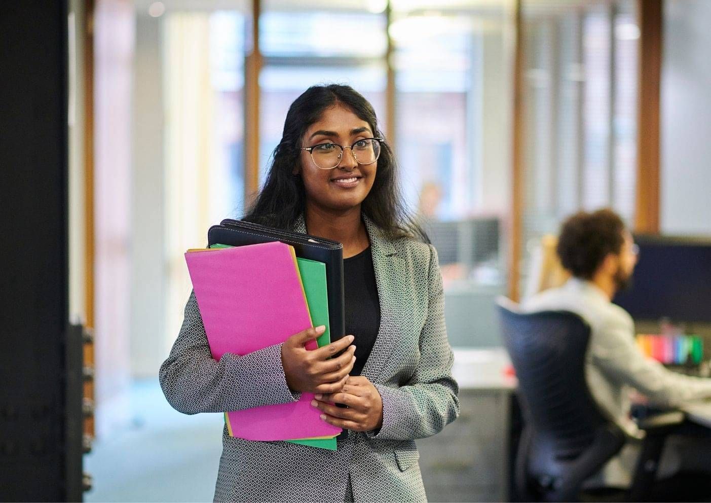 International student walking on campus holding her course folder