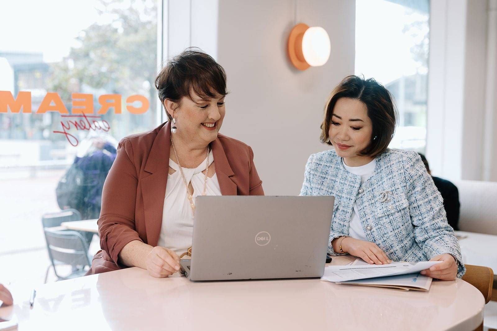 Immigration adviser talking a client through her residence options at a laptop