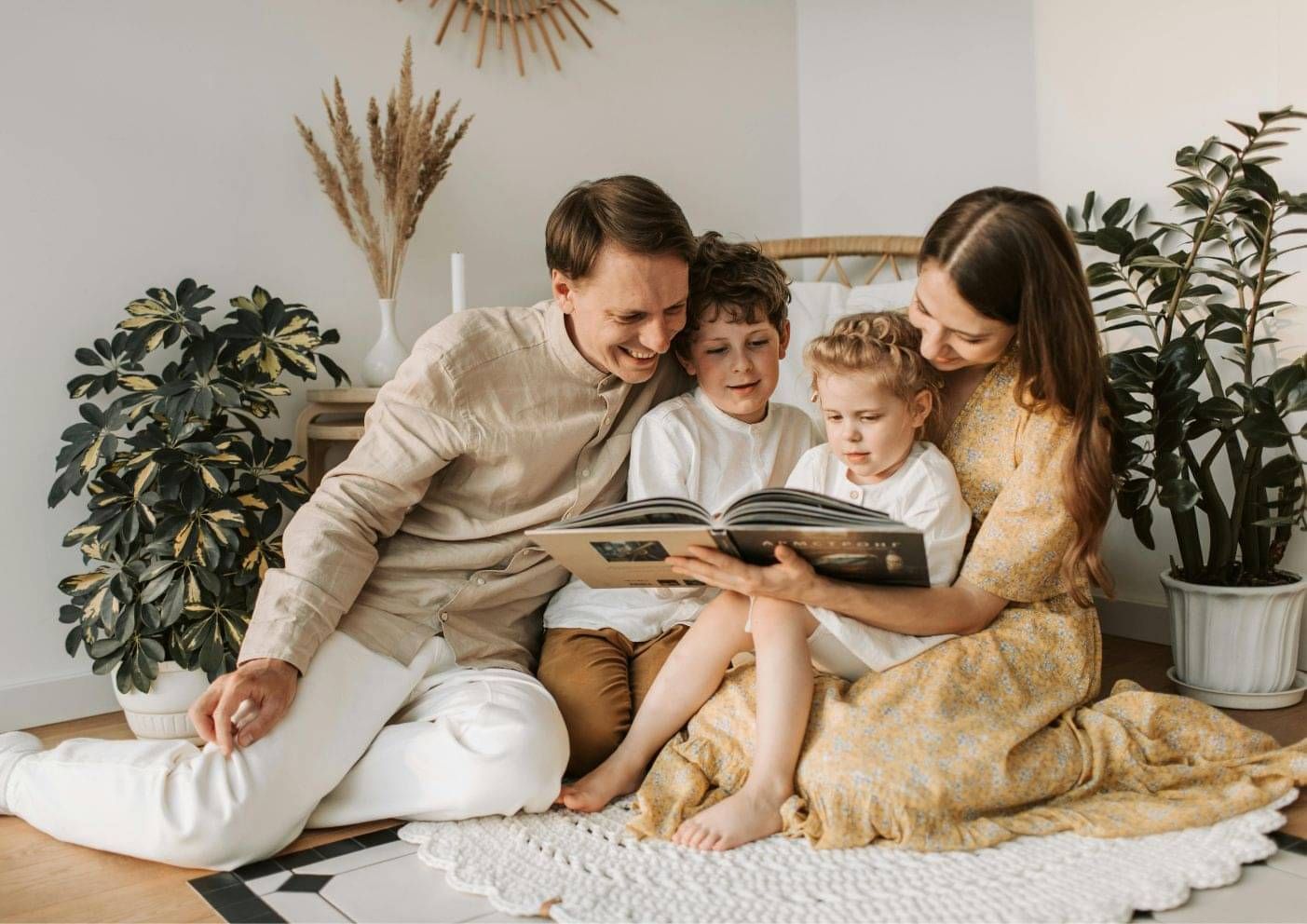 Parents and two young children reading together at home in New Zealand