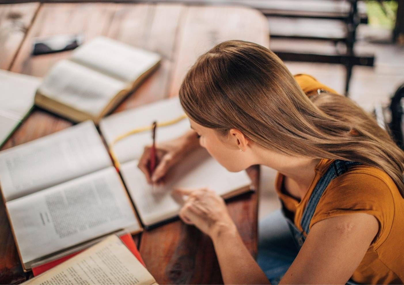 International student taking notes from a textbook while studying in New Zealand