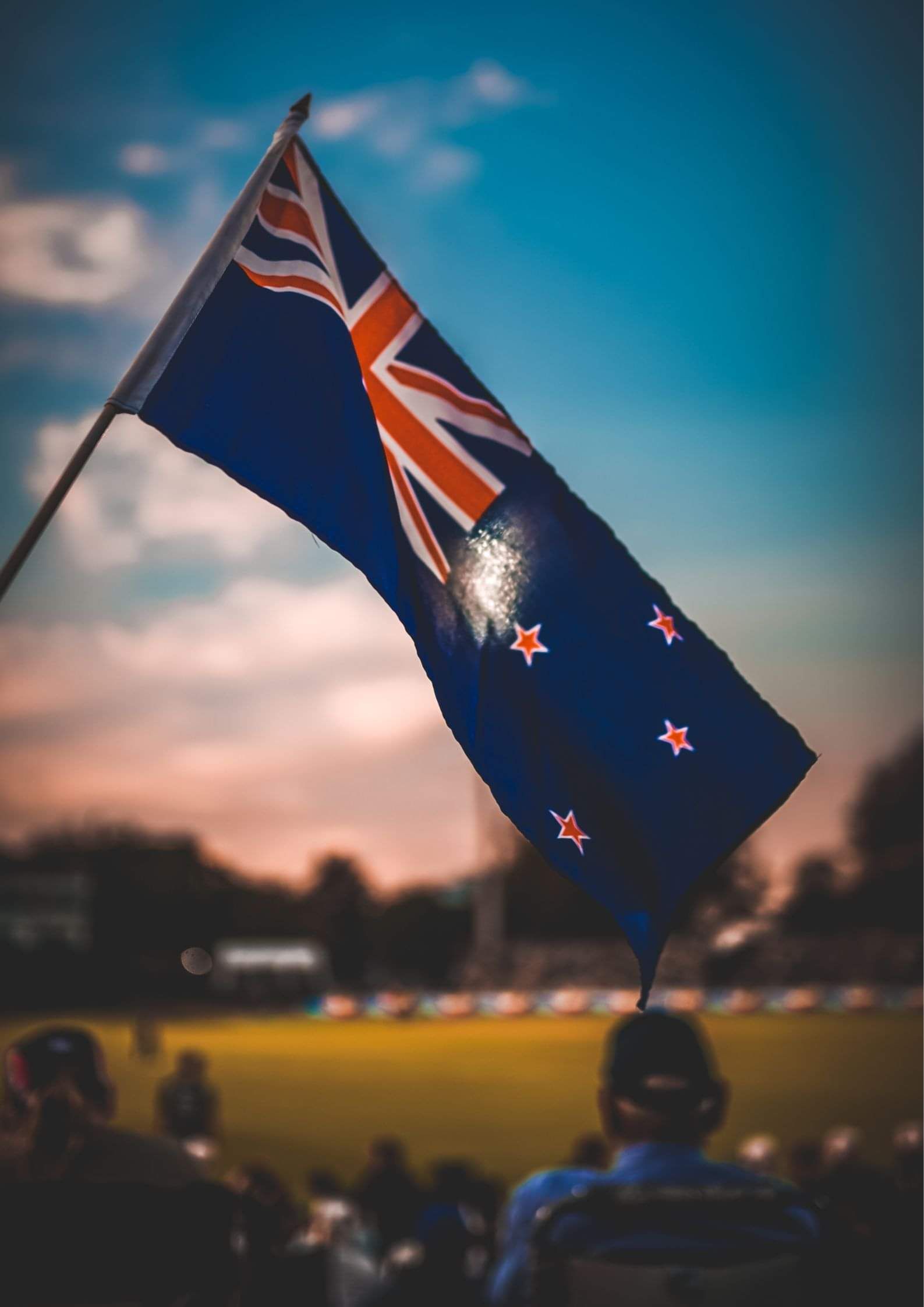 New Zealand flag flying at dusk, marking the final step of becoming a New Zealander