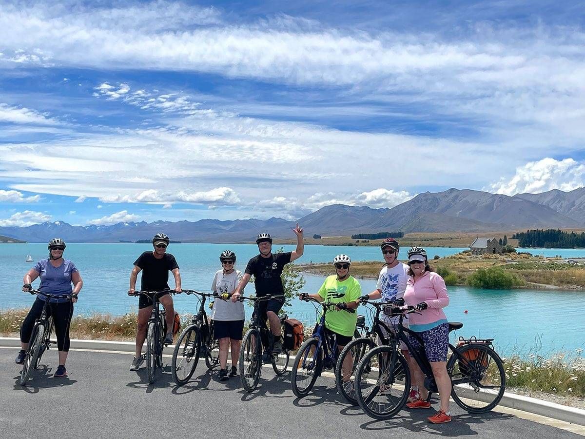 Riders posing for a photo amongst NZs amazing scenery with Pacific Cycle Tours in New Zealand