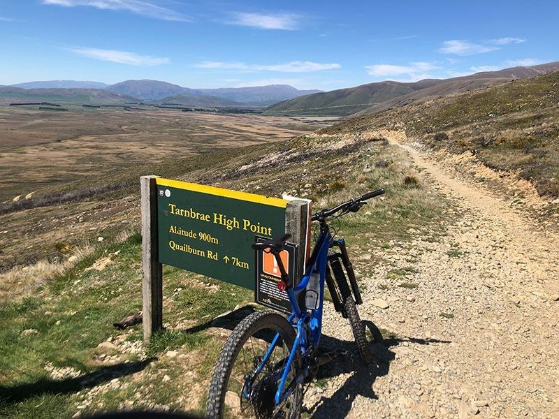 A bike against a trail sign with Pacific Cycle Tours in New Zealand