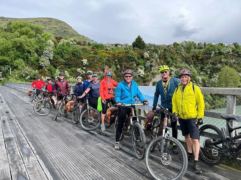 Riders pose on a bridge on tour with Pacific Cycle Tours Christchurch