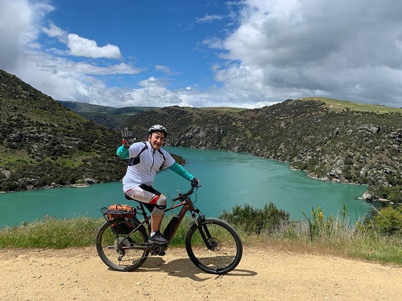 Rider waves at us on tour with Pacific Cycle Tours Christchurch