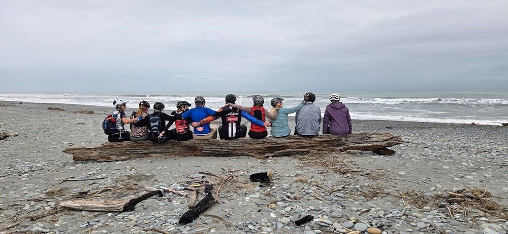 Small groups of riders on a log at the beach