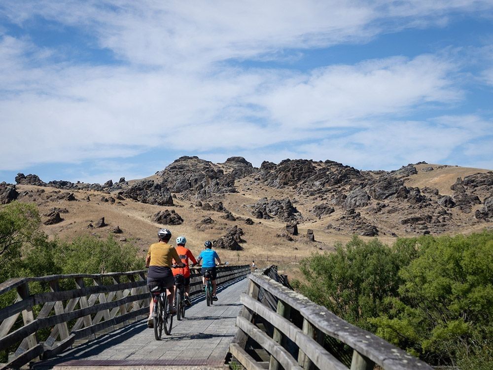 Riders zoom along a bridge on the Otago Central Rail Trail