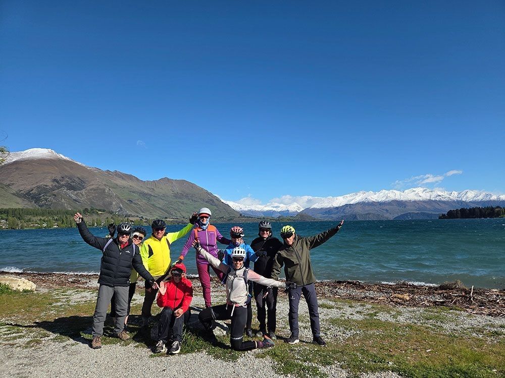 A group of riders posing by the lake with the Southern Alps in the background