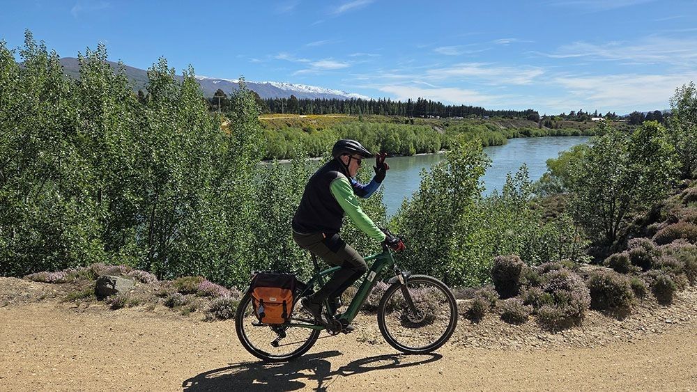 Riders waves to the camera while enjoying New Zealands best trails