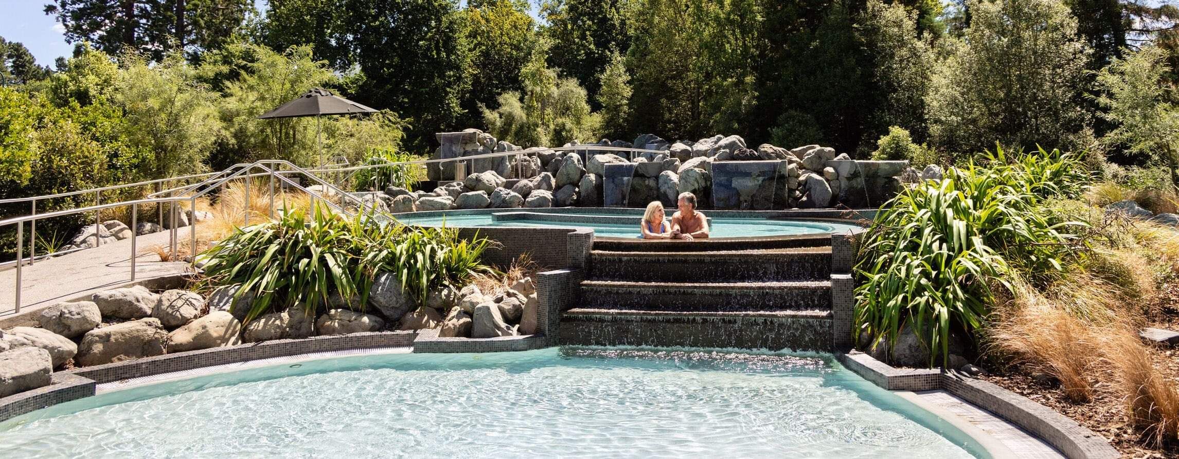 Couple relax in a hot pool at Hanmer Springs