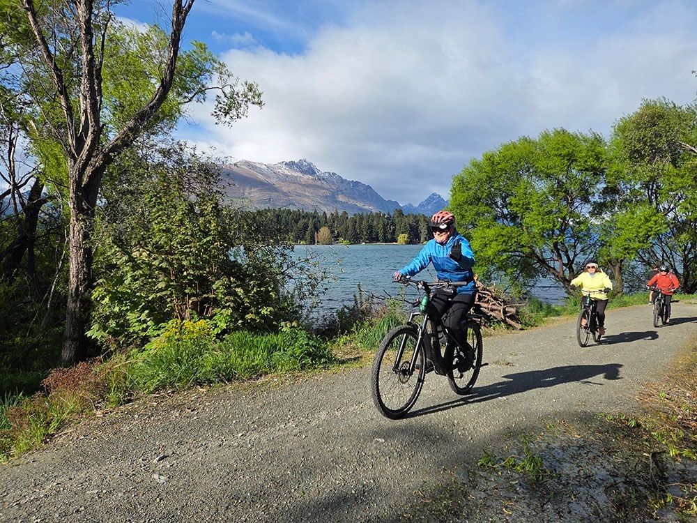 Rider waves to the camera while riding the best trails in New Zealand