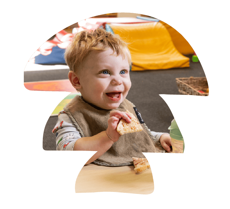 A smiling toddler enjoying lunch at Sunshine on Sunshine.
