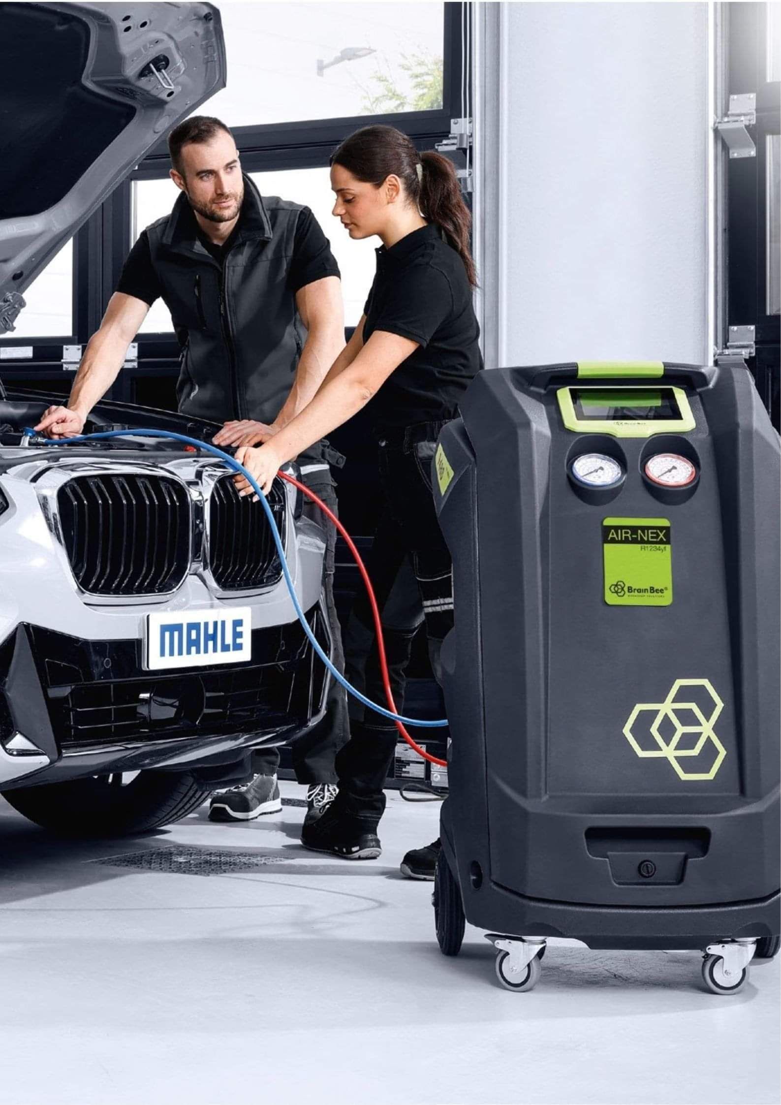 Automotive technicians working on vehicle air conditioning system
