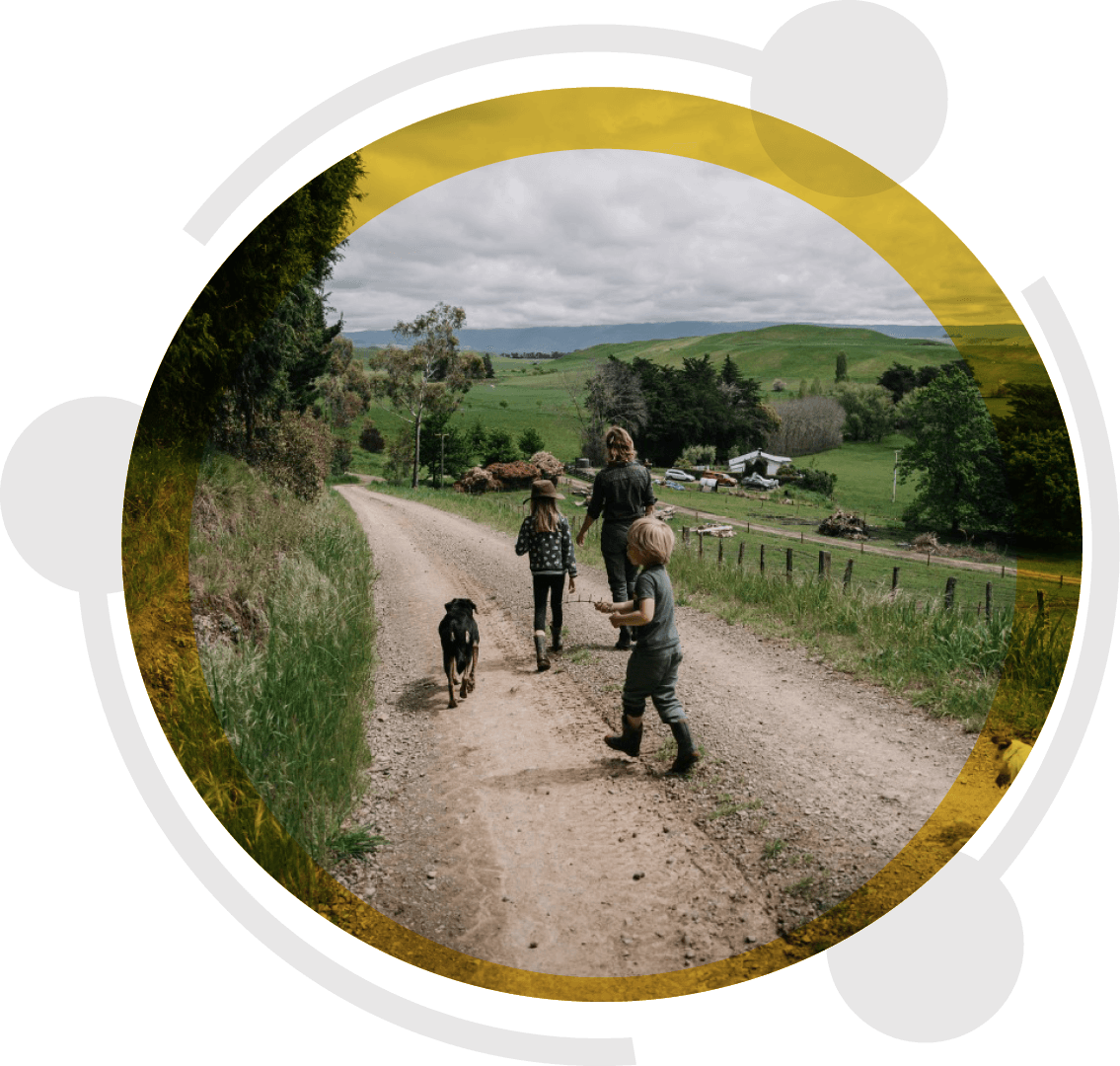 A family and their dog walking down a gravel farm road in rural South Canterbury, where Ezykonect delivers rural broadband