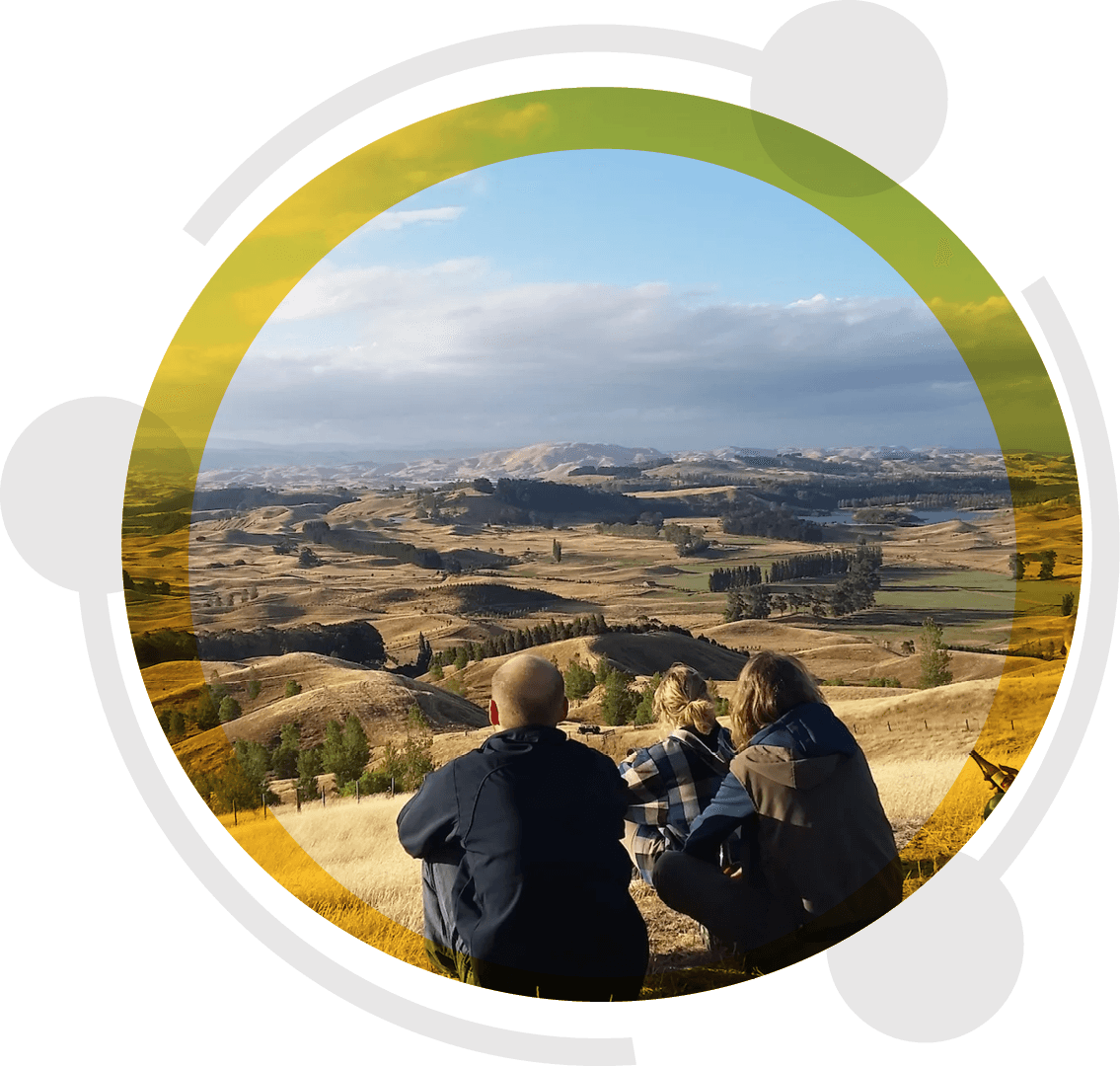 Three locals sitting on a hilltop overlooking rolling golden hills in Waitaki, home to Ezykonect's family-owned rural broadband